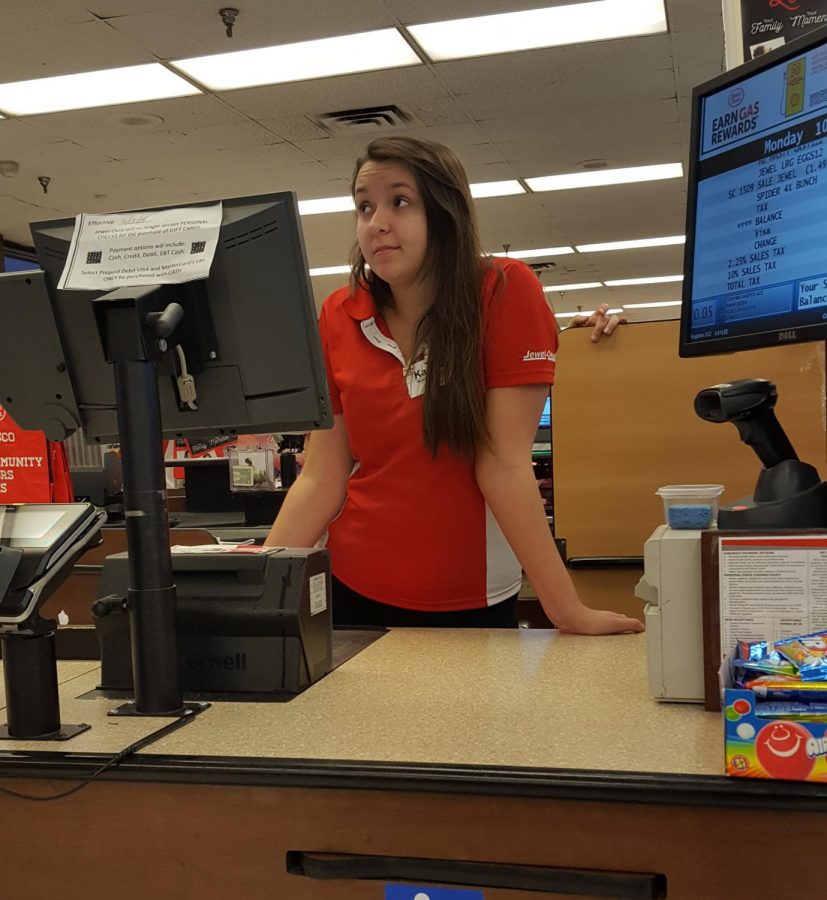 Kaylee+Kalvig+awaits+her+next+customer+in+the+check+out+line+at+Jewel.+