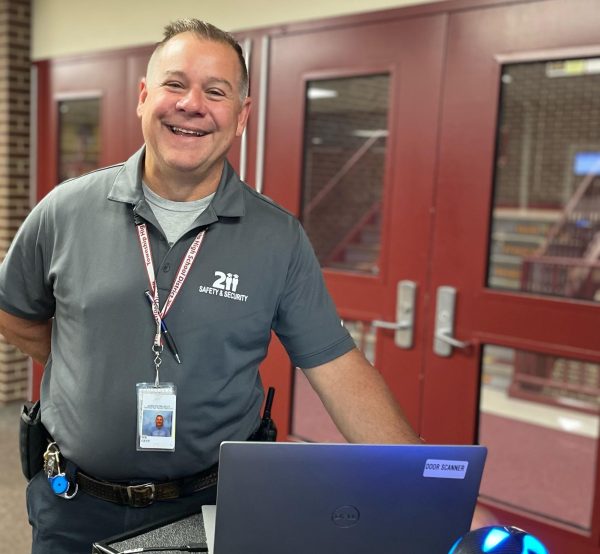 Safety and Security personnel Mike Gust checks students IDs as they enter the building. 