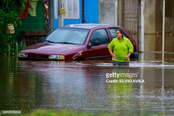 A woman walks through a flooded street in Porto Alegre, Brazil on September 27, 2023. The state of Rio Grande do Sul suffered a cyclone that destroyed the cities of Mucum and Roca Sales in the beginning of September 2023, and now its suffering the action of a new extratropical cyclone that intensified the storms and caused flooding in several cities in the state in southern Brazil. (Photo by SILVIO AVILA / AFP) (Photo by SILVIO AVILA/AFP via Getty Images)