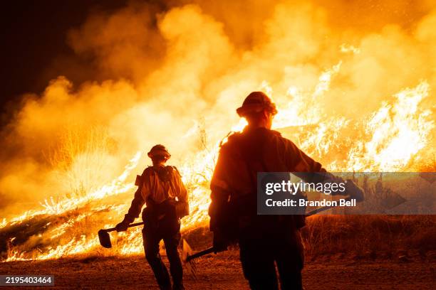 CASTAIC, CALIFORNIA - JANUARY 22: Firefighters work as the Hughes Fire burns on January 22, 2025 in Castaic, California. The wildfire has spread 9,400 acres and has prompted mandatory evacuations just over two weeks after the Eaton and Palisades Fires caused widespread destruction across Los Angeles County. (Photo by Brandon Bell/Getty Images)